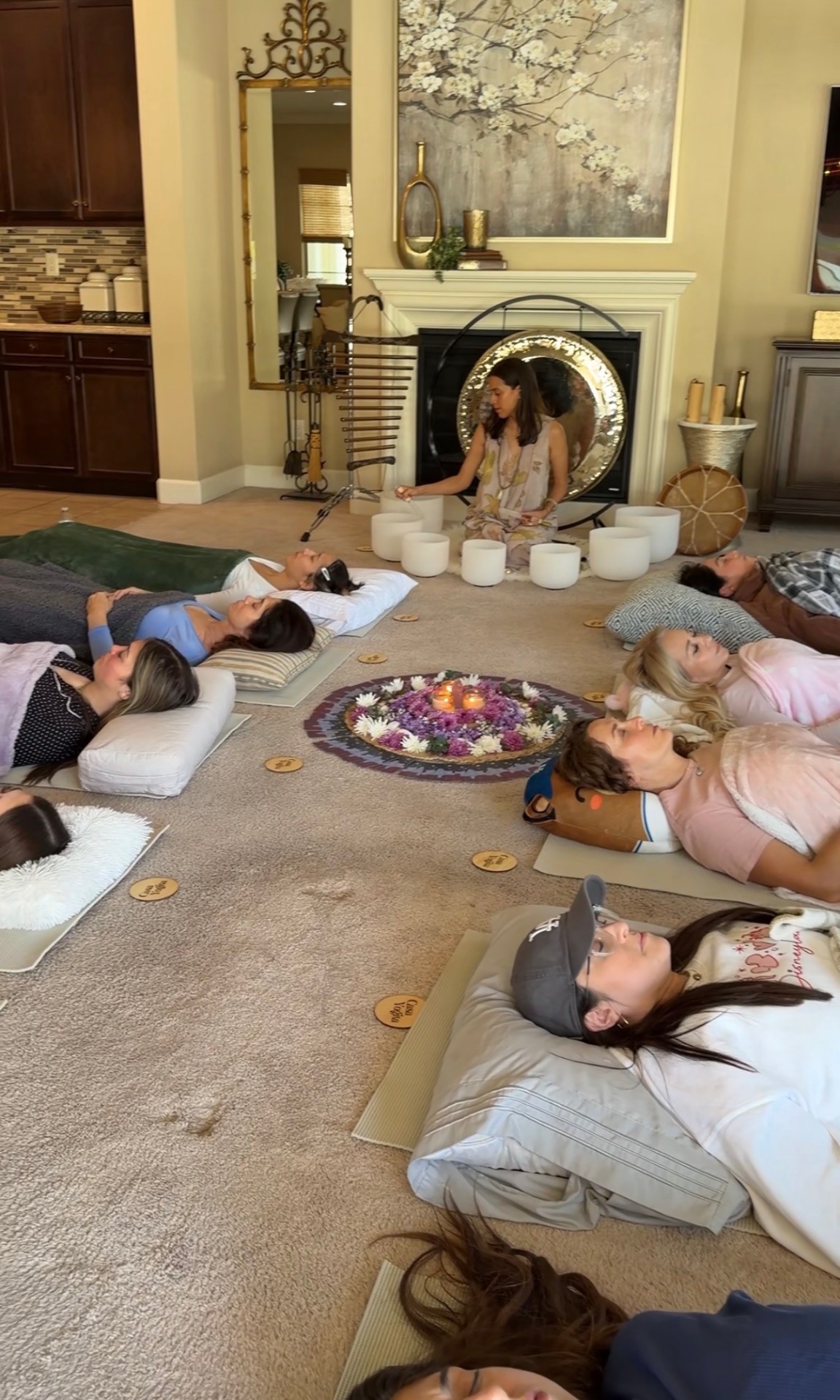 A Casa Yogita sound bath in a living room. Crystal singing bowls, floor cushions, guests resting
